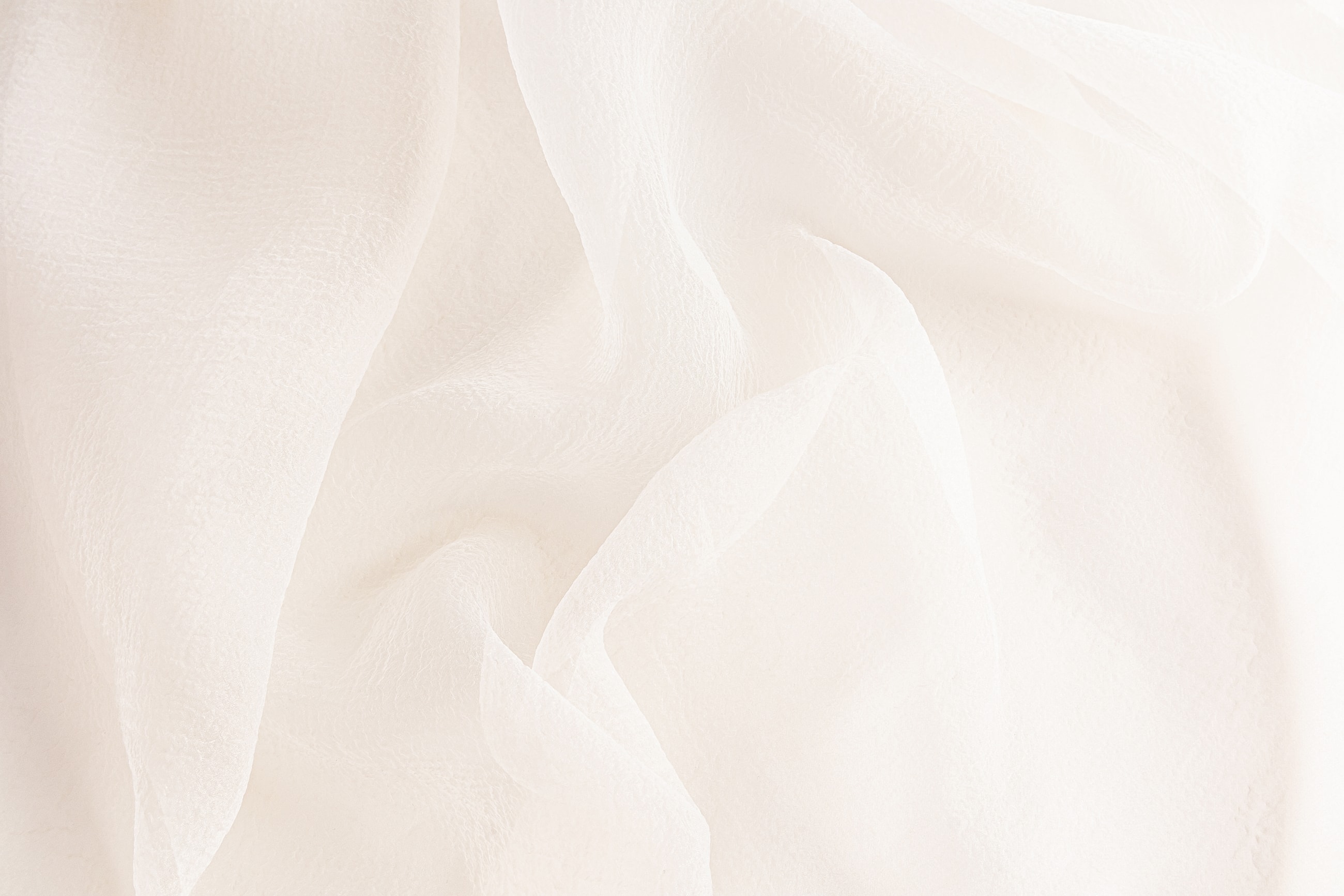Soft, flowing white fabric texture background.