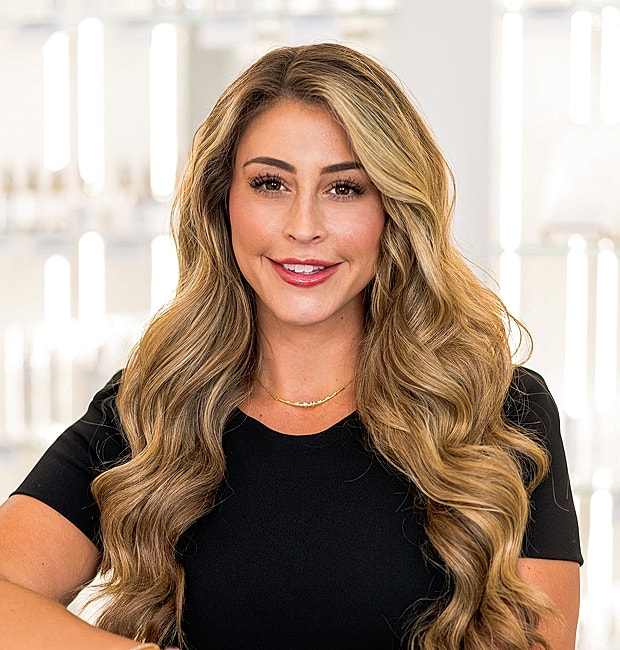 Smiling woman with wavy hair in black top.
