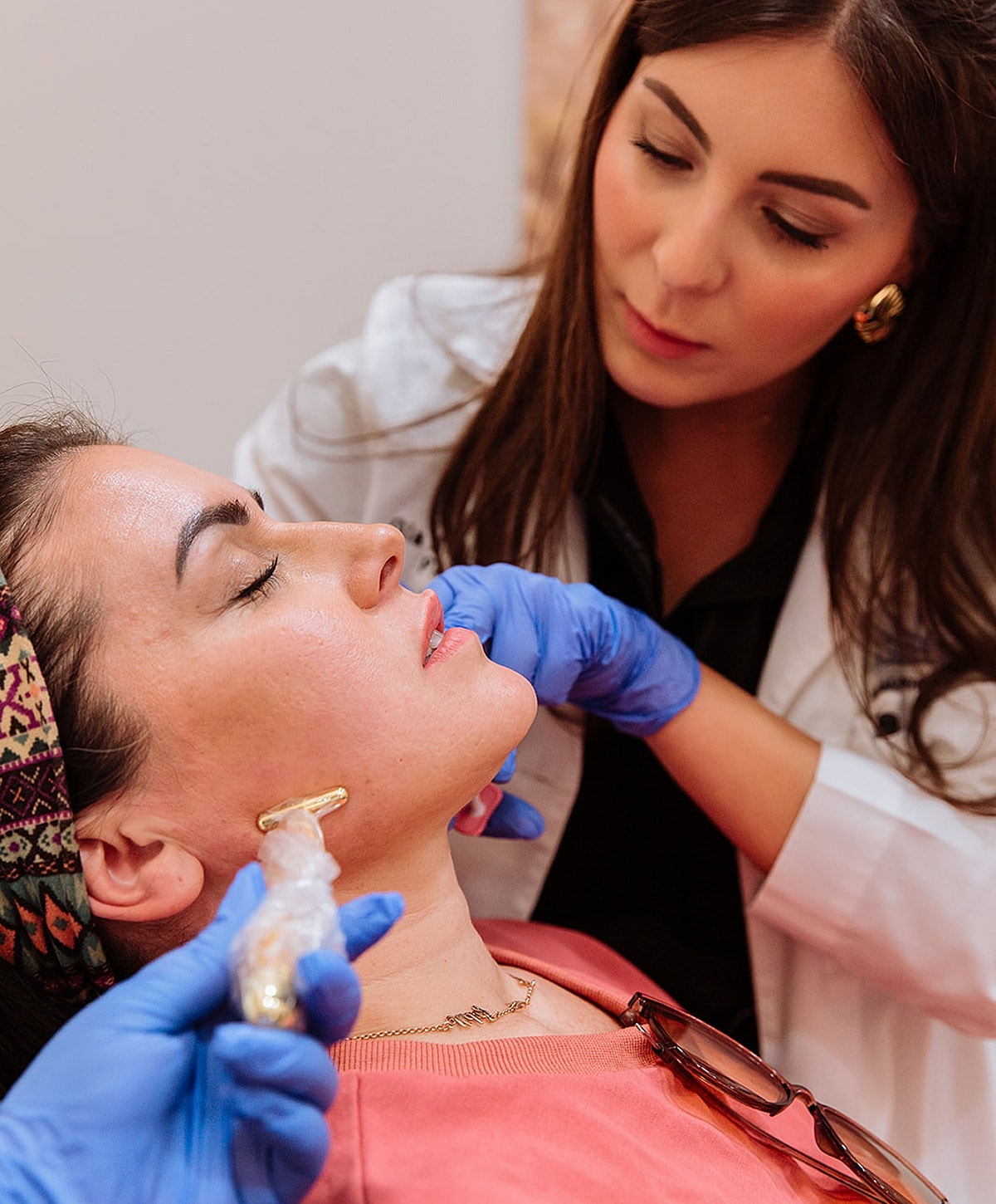 Model in white turtleneck against gray background.