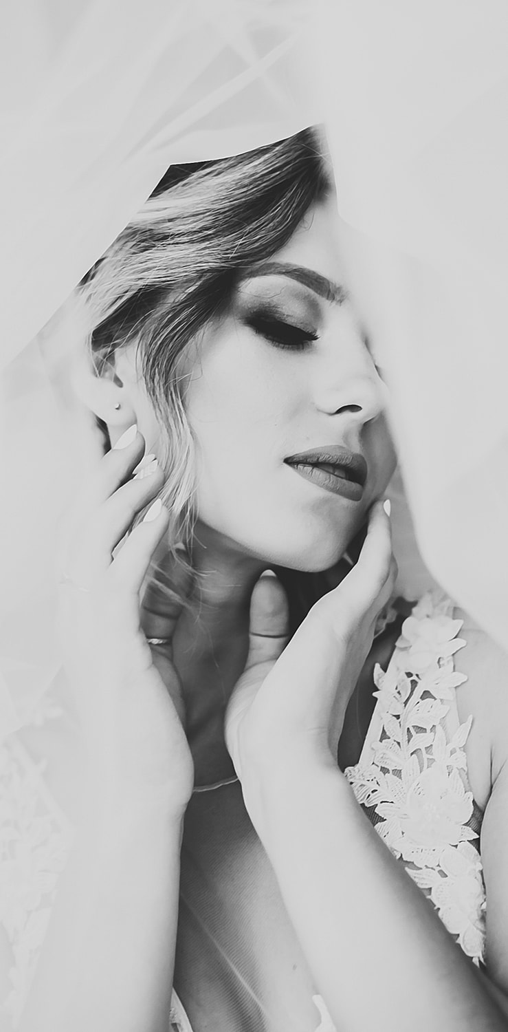 Bride under veil, soft black and white portrait.