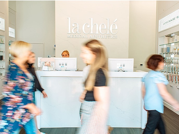 Busy aesthetic clinic reception with clients arriving.