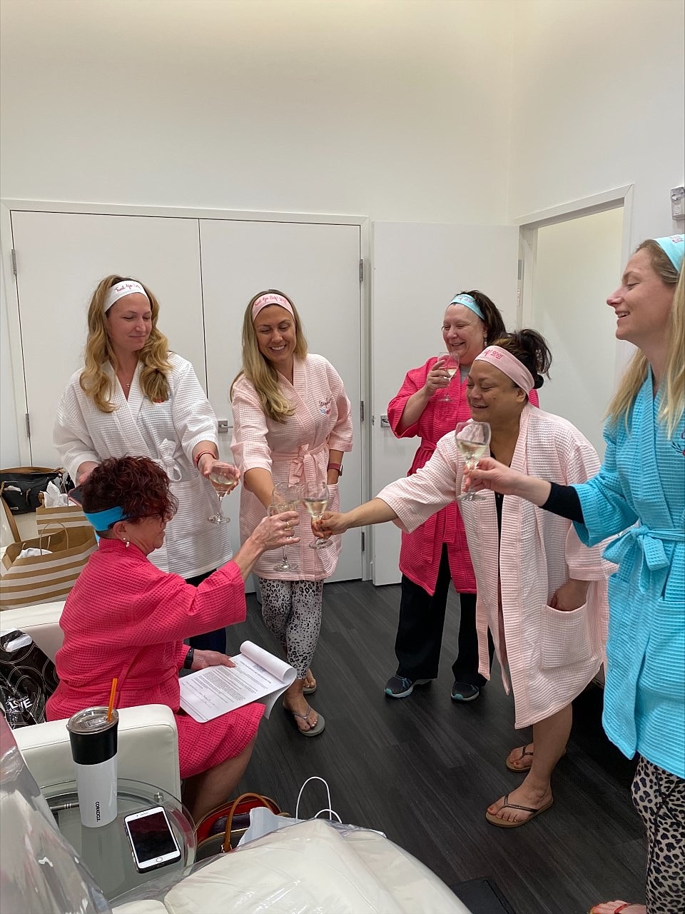 Group of women celebrating in spa robes.