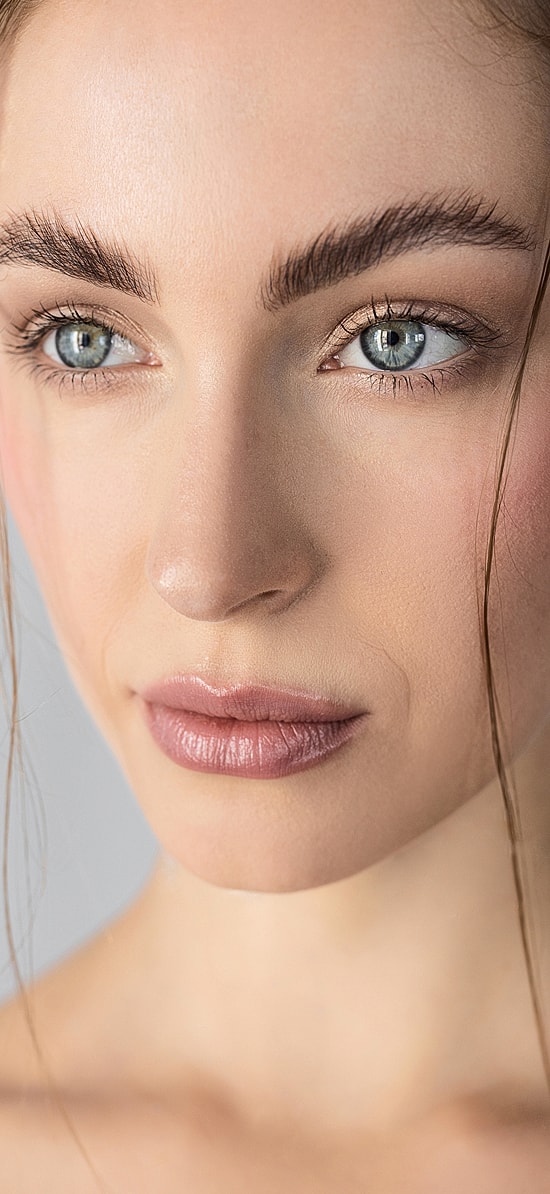 Woman with styled hair and natural makeup.