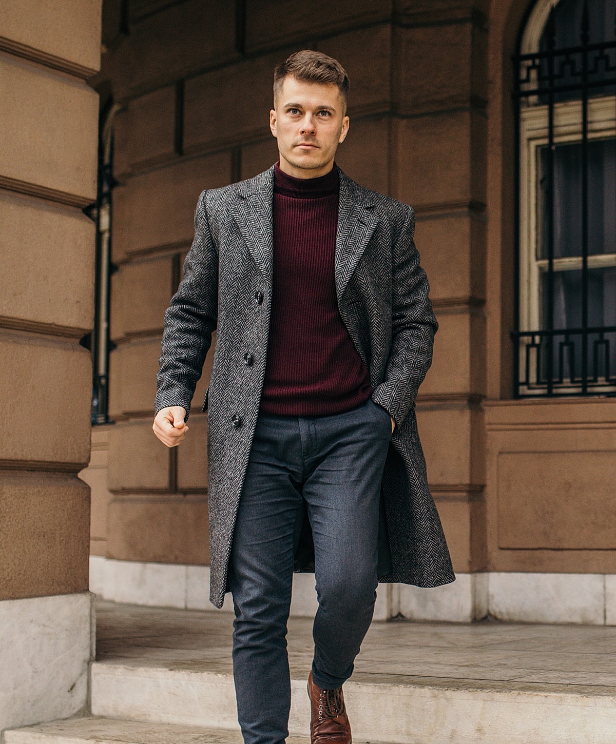 Man walking in stylish coat and sweater.