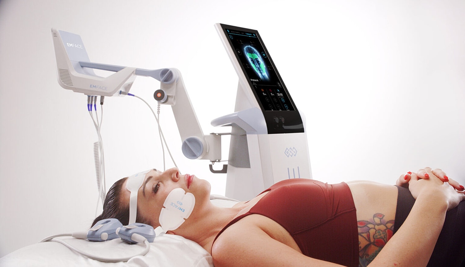 Patient receiving facial treatment with EMFACE device.