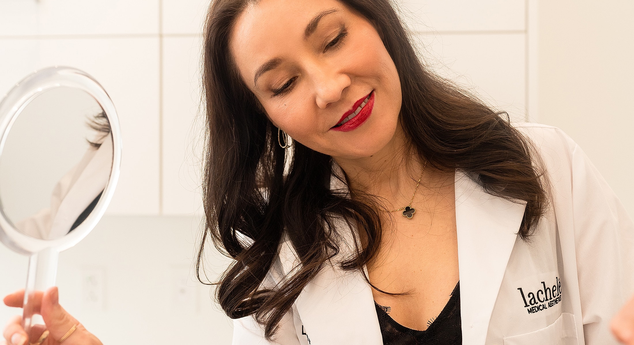 Woman applying makeup in medical aesthetic setting.