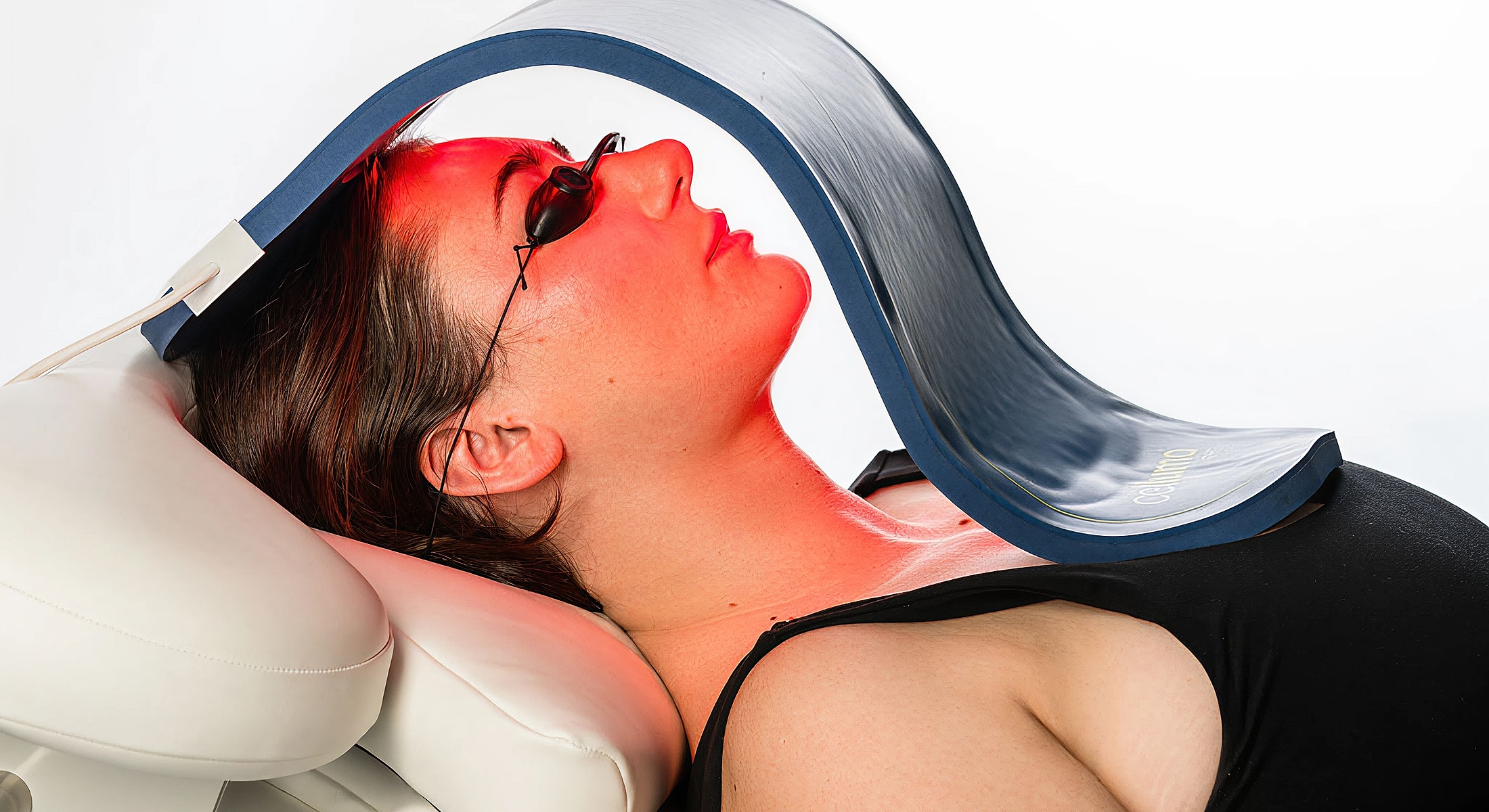 Woman receiving red light therapy treatment.