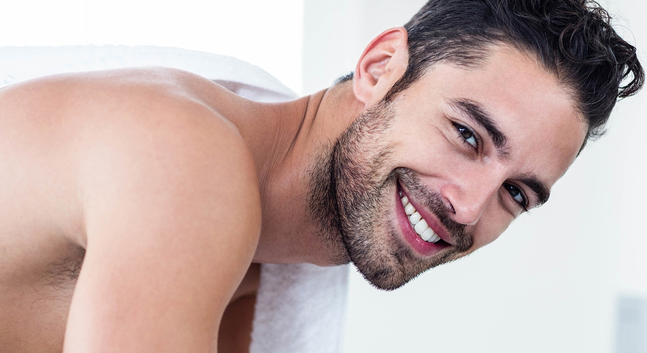 Smiling man wrapped in a towel.